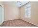 Neutral bedroom featuring a window with bright sunlight, carpet, and white closet doors at 2167 Shadow Canyon Dr, Henderson, NV 89044