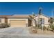 A tan single-story home featuring a two-car garage and desert landscaping at 2167 Shadow Canyon Dr, Henderson, NV 89044
