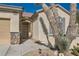 Exterior showcasing an arched doorway, two-car garage, and desert landscaping at 2167 Shadow Canyon Dr, Henderson, NV 89044