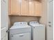 Laundry room featuring front load washer, dryer, and wooden cabinets at 2167 Shadow Canyon Dr, Henderson, NV 89044