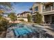 Private backyard features a luxurious pool, spa, mature landscaping, and inviting lounge chairs at 2215 Alcova Ridge Dr, Las Vegas, NV 89135