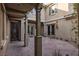 Charming courtyard featuring a decorative door, stucco walls, and lush greenery, creating a private outdoor space at 2215 Alcova Ridge Dr, Las Vegas, NV 89135