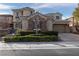 Beautiful home exterior featuring stone detailing, mature landscaping, and a spacious driveway, enhancing its overall charm at 2215 Alcova Ridge Dr, Las Vegas, NV 89135