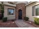 Stylish front door with stone archway, creating a welcoming entrance, complemented by manicured landscaping at 2215 Alcova Ridge Dr, Las Vegas, NV 89135