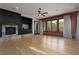 Spacious living room featuring a fireplace, ceiling fan, large windows, and hardwood floors at 2215 Alcova Ridge Dr, Las Vegas, NV 89135