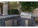 Built-in outdoor kitchen with stainless steel grill, fridge and extra counter space for cooking at 2215 Alcova Ridge Dr, Las Vegas, NV 89135