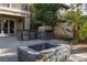 Well-equipped outdoor kitchen with stone counters, grill, fridge, and cozy firepit area for entertaining at 2215 Alcova Ridge Dr, Las Vegas, NV 89135