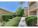 A lush walkway bordered by manicured bushes leading to the building at 2300 E Silverado Ranch Blvd # 1123, Las Vegas, NV 89183