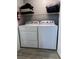 This laundry room features a modern washer and dryer set and ample overhead storage shelving at 2300 E Silverado Ranch Blvd # 1123, Las Vegas, NV 89183
