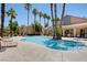 Community pool surrounded by palm trees, lounge chairs, and the building at 2300 E Silverado Ranch Blvd # 1123, Las Vegas, NV 89183