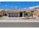 Charming single-story home with a tile roof, desert landscaping, and an attached two-car garage at 2305 Hot Oak Ridge St, Las Vegas, NV 89134