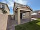 A covered brick patio looks out over a compact backyard with a privacy wall at 2321 Teatro Ave, Henderson, NV 89044