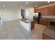 Open kitchen with island, stainless steel appliances, granite countertops, and a seamless flow to the living area at 2321 Teatro Ave, Henderson, NV 89044