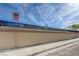 Street view of a concrete block and iron fence securing a single-story home under a partly cloudy sky at 2832 Geist Cir, Las Vegas, NV 89115