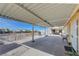 View of the covered patio with concrete floor, cinder block wall, and access to a detached garage in the backyard at 2832 Geist Cir, Las Vegas, NV 89115