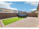Spacious backyard featuring a brick patio, artificial grass, and a trampoline at 2877 Sweeping Palm Rd, North Las Vegas, NV 89086