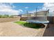 Large backyard featuring a brick patio, artificial grass, and a trampoline at 2877 Sweeping Palm Rd, North Las Vegas, NV 89086