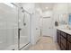 Bright bathroom featuring a glass-enclosed shower, tile flooring, and vanity with solid surface counter at 2877 Sweeping Palm Rd, North Las Vegas, NV 89086