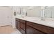 Bathroom features double sink vanity with dark wood cabinets and a full mirror, plus a white door at 2877 Sweeping Palm Rd, North Las Vegas, NV 89086