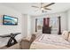 Bright bedroom features a ceiling fan, TV, dresser, comfortable seating, and natural light from the windows at 2877 Sweeping Palm Rd, North Las Vegas, NV 89086