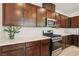 Well-lit kitchen with stainless steel appliances, dark wood cabinets, and white countertops at 2877 Sweeping Palm Rd, North Las Vegas, NV 89086