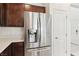 Modern stainless steel refrigerator next to white doors and dark wood cabinets at 2877 Sweeping Palm Rd, North Las Vegas, NV 89086