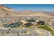 Expansive aerial view of a community featuring a clubhouse, tennis courts, and desert landscape at 3000 Dusky Willow Ln, Las Vegas, NV 89138