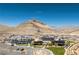 Panoramic aerial shot showcasing community with a clubhouse, pool, tennis courts, and mountain views at 3000 Dusky Willow Ln, Las Vegas, NV 89138