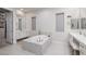 Serene bathroom with soaking tub, dual vanities, and a walk-in closet at 3000 Dusky Willow Ln, Las Vegas, NV 89138