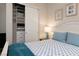 Bright bedroom featuring a closet with shelving and drawers, and a cozy bed with blue accents at 3000 Dusky Willow Ln, Las Vegas, NV 89138