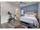 Cozy bedroom featuring blue accent wall, home gym, and ensuite bathroom at 3000 Dusky Willow Ln, Las Vegas, NV 89138
