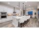 Bright kitchen features stainless appliances, an island with seating, and grey wood flooring at 3000 Dusky Willow Ln, Las Vegas, NV 89138