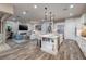 Modern open concept kitchen view of island with seating and view of living room with fireplace at 3000 Dusky Willow Ln, Las Vegas, NV 89138