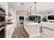 Modern white kitchen with an island and seating and a view to the backyard and dining room at 3000 Dusky Willow Ln, Las Vegas, NV 89138