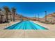 A long lap pool with lane markers, desert landscape, mountain views and lounge chairs under a clear blue sky at 3000 Dusky Willow Ln, Las Vegas, NV 89138