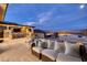 Spacious outdoor living area with a kitchen, bar seating, fire pit, and comfortable lounging at 3000 Dusky Willow Ln, Las Vegas, NV 89138
