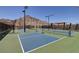 Outdoor pickleball courts with mountain views, surrounded by a secure fence and well-lit with street lamps at 3000 Dusky Willow Ln, Las Vegas, NV 89138
