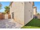 This backyard features stone pavers, an easy to care for lawn, and partial privacy wall at 3314 Villa Fiori Ave, Las Vegas, NV 89141
