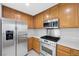 A kitchen showcases stainless steel appliances, light countertops, and wooden cabinets at 3314 Villa Fiori Ave, Las Vegas, NV 89141