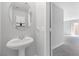 A powder room featuring a stylish sink, round mirror, and light gray walls at 3314 Villa Fiori Ave, Las Vegas, NV 89141