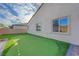 This backyard includes a putting green and a well-maintained wall surrounding the space at 3495 Luca Point Ave, Henderson, NV 89044