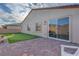 This backyard includes a putting green, brick-lined patio, and a gas grill at 3495 Luca Point Ave, Henderson, NV 89044