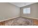 A simple bedroom featuring a window with blinds, wood-look flooring, and decorative rug at 3495 Luca Point Ave, Henderson, NV 89044
