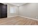Clean, minimal bedroom with modern door, wood-look floors and window at 3495 Luca Point Ave, Henderson, NV 89044