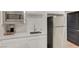 A close-up of the kitchenette, featuring a stainless-steel refrigerator, microwave, and a sink with white cabinets at 3495 Luca Point Ave, Henderson, NV 89044