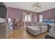 Primary bedroom with wood floors, ceiling fan, and comfortable seating area at 390 Inflection St, Henderson, NV 89011