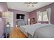 Primary bedroom featuring wood floors, ceiling fan and large television at 390 Inflection St, Henderson, NV 89011
