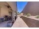 Covered patio featuring an outdoor kitchen with grill, ceiling fans, and desert landscaping in a peaceful backyard setting at 390 Inflection St, Henderson, NV 89011