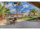 Spacious backyard with a built-in barbecue area, desert landscaping, and palm trees at 4134 Riva De Tierra Ln, Las Vegas, NV 89135