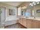 Bathroom with a large tub, enclosed shower, and double sink vanity at 4134 Riva De Tierra Ln, Las Vegas, NV 89135